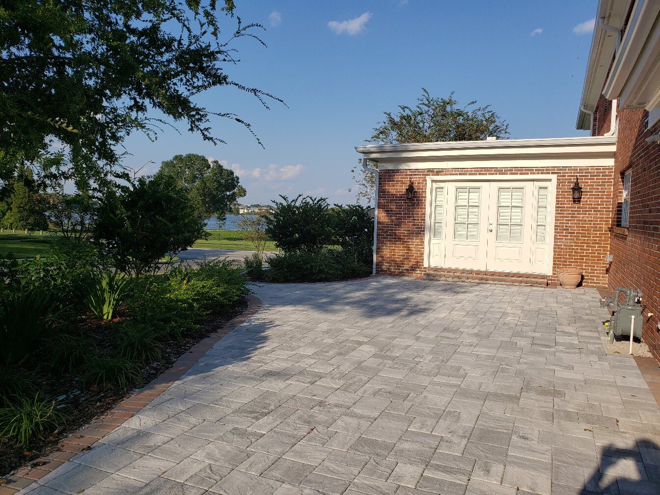 Paver driveway beside brick home