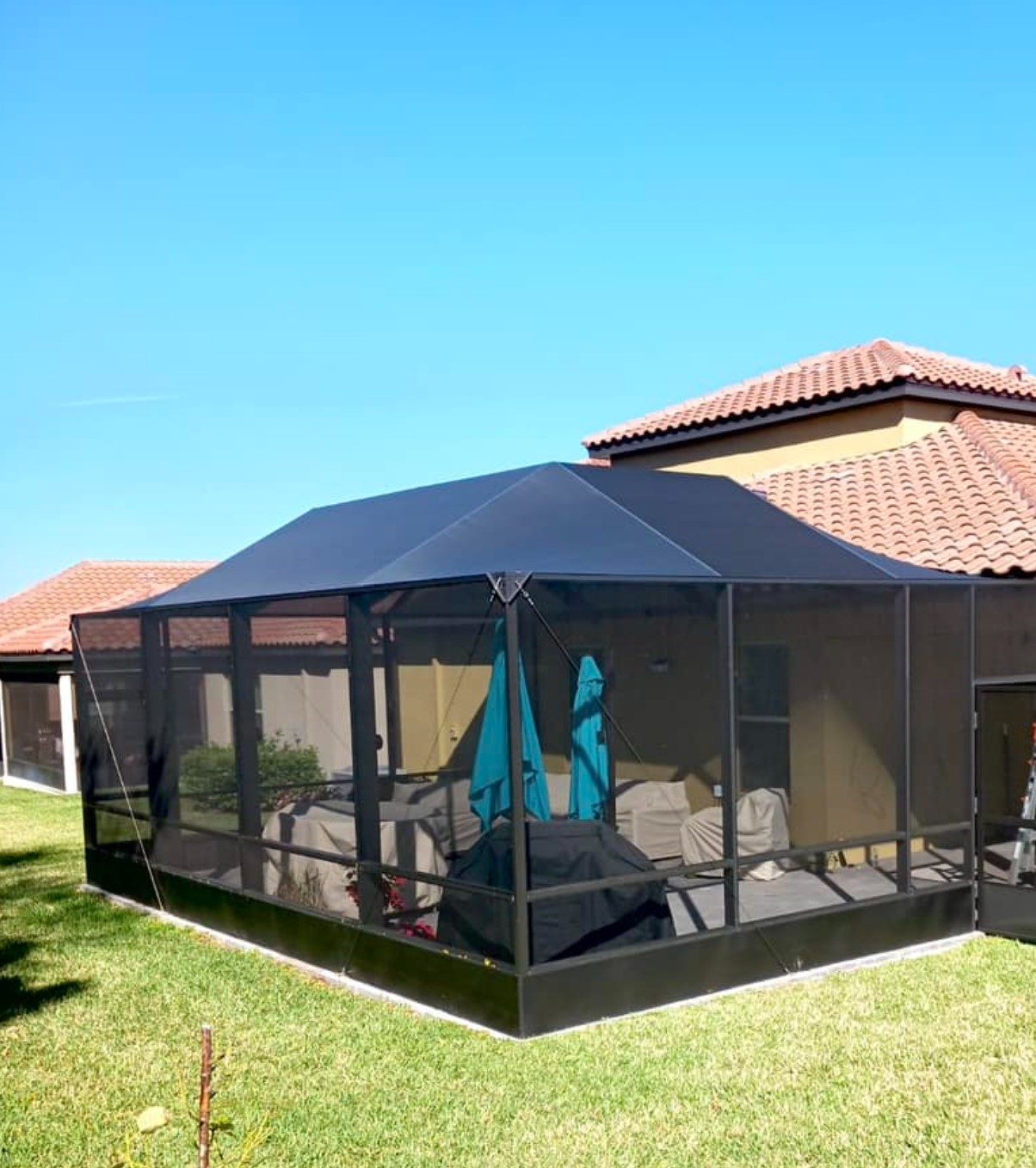 Freestanding screened room enclosure in a Florida backyard