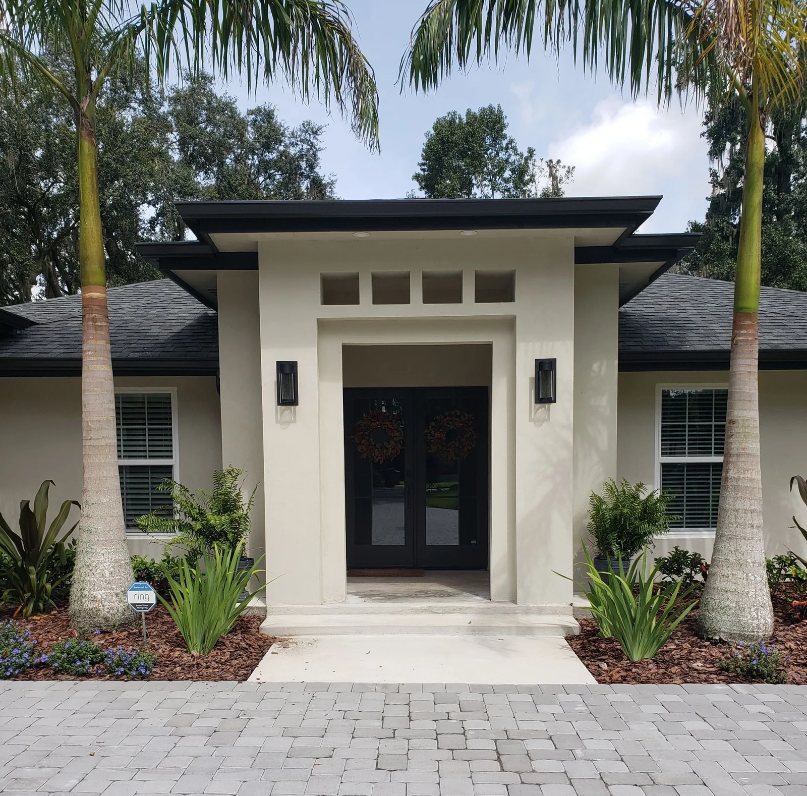 Contemporary front entry with black double doors and sidelights